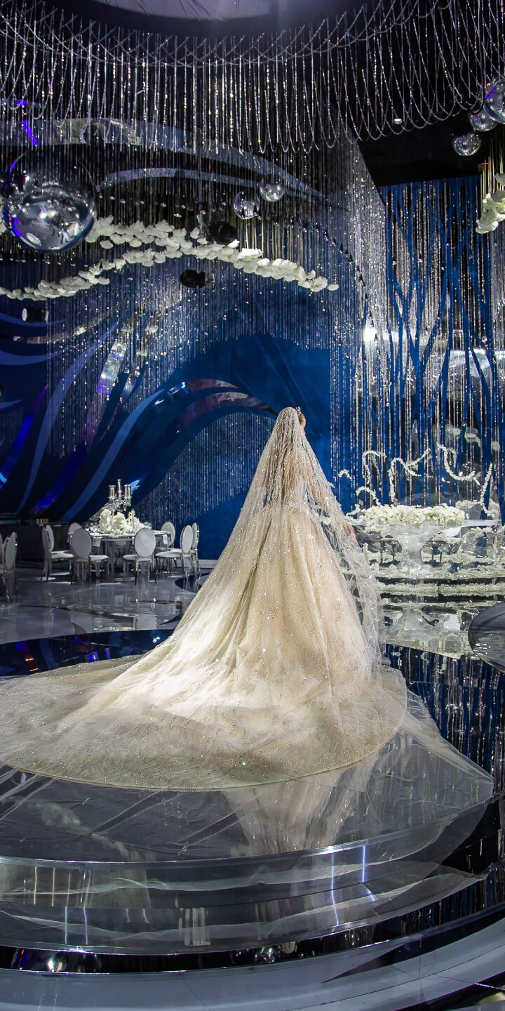 Невеста со спины в роскошно декорированном зале