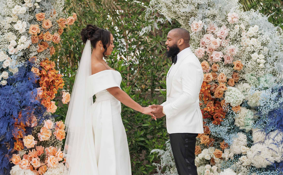 Молодожены во время свадеьбной церемонии на фоне зеленого ландшафта